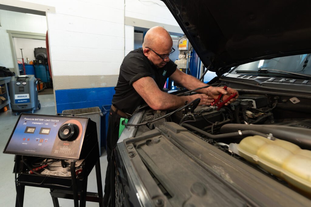 Technician performing a battery load test on a vehicle at Chuck’s Auto Repair – Shoreline.