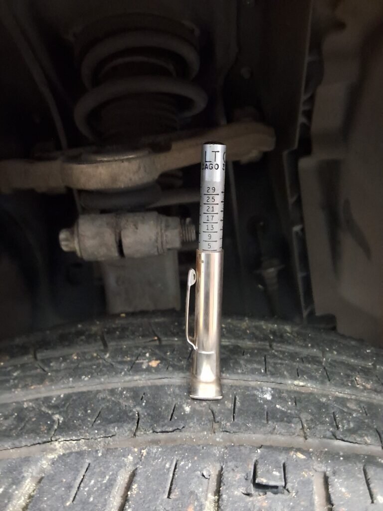 Tire tread depth being measured during a vehicle inspection at Chuck’s Auto Repair – Shoreline.