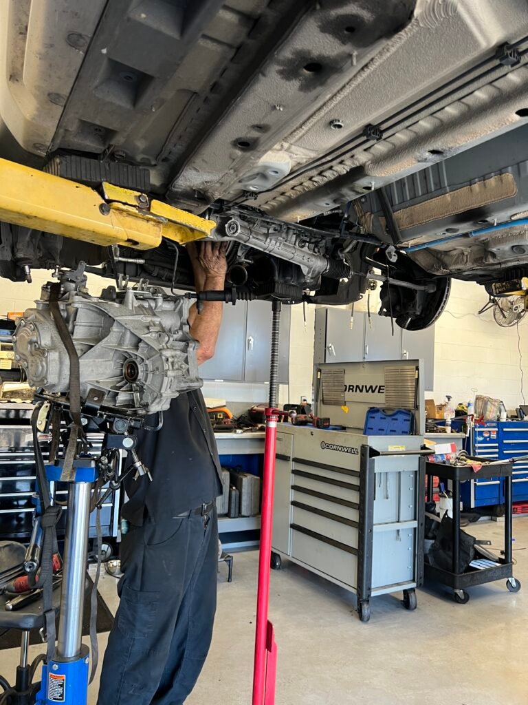 Manual transmission being removed from a MINI Countryman S ALL4 during clutch replacement.