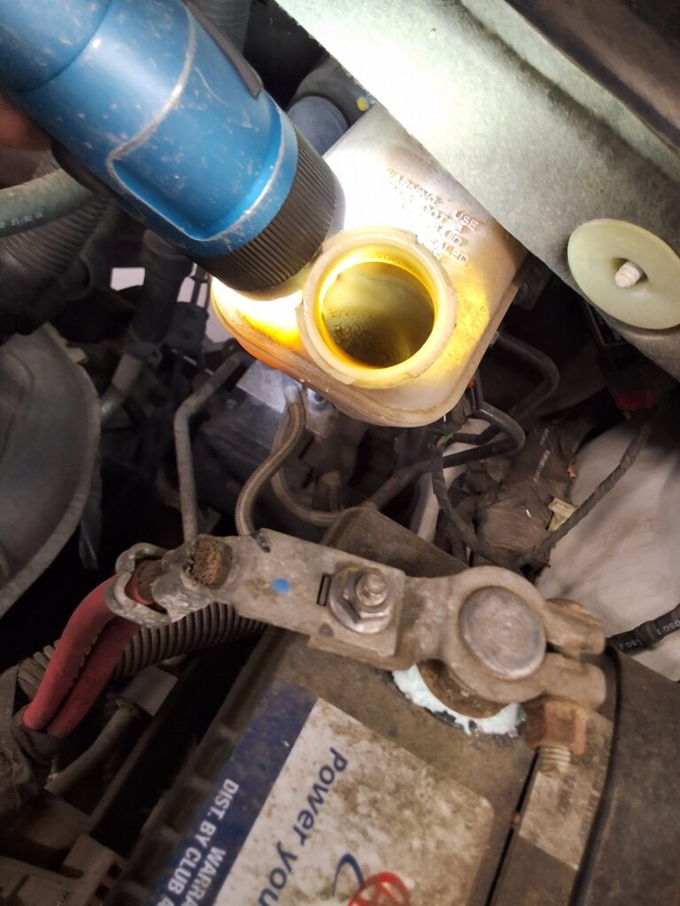 Brake fluid reservoir inspected during brake diagnosis on a Chrysler Town & Country.