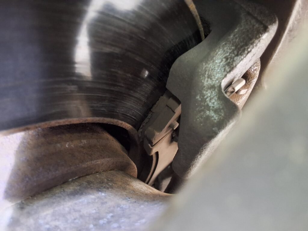 Front brake components on a Chrysler Town & Country showing visible wear during inspection.